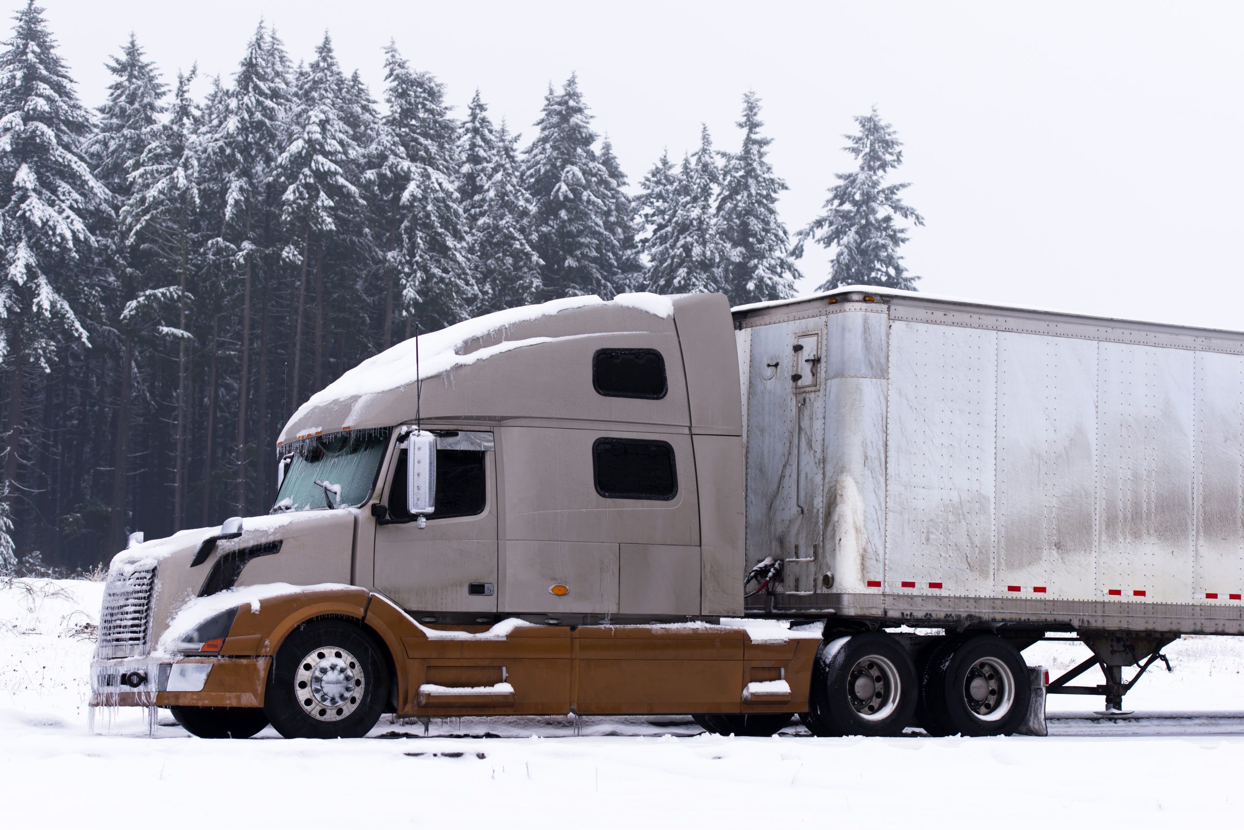 Two color modern semi truck and trailer in winter wether