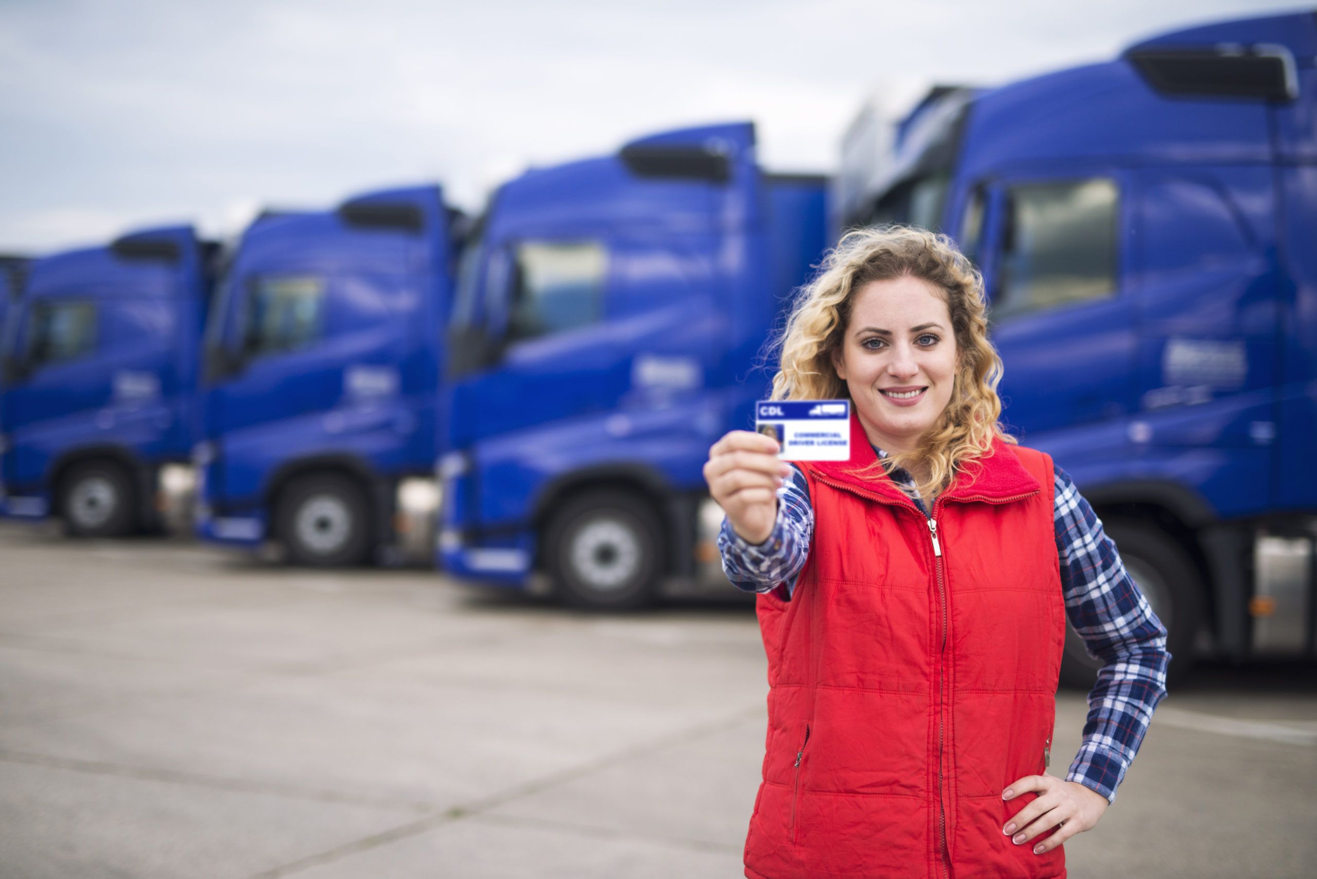 Woman truck driver proudly holding commercial driving license. I