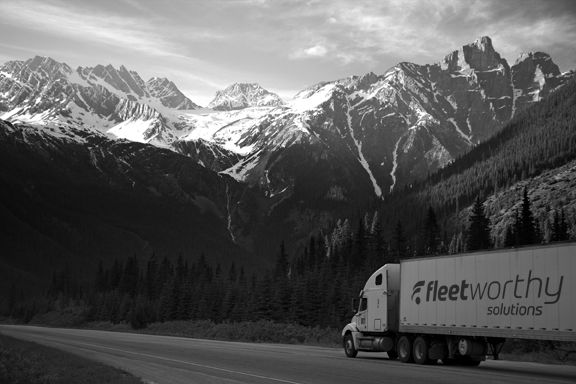 white-truck-near-pine-tress-during-daytime-low-res-grayscale-vehicle+logo